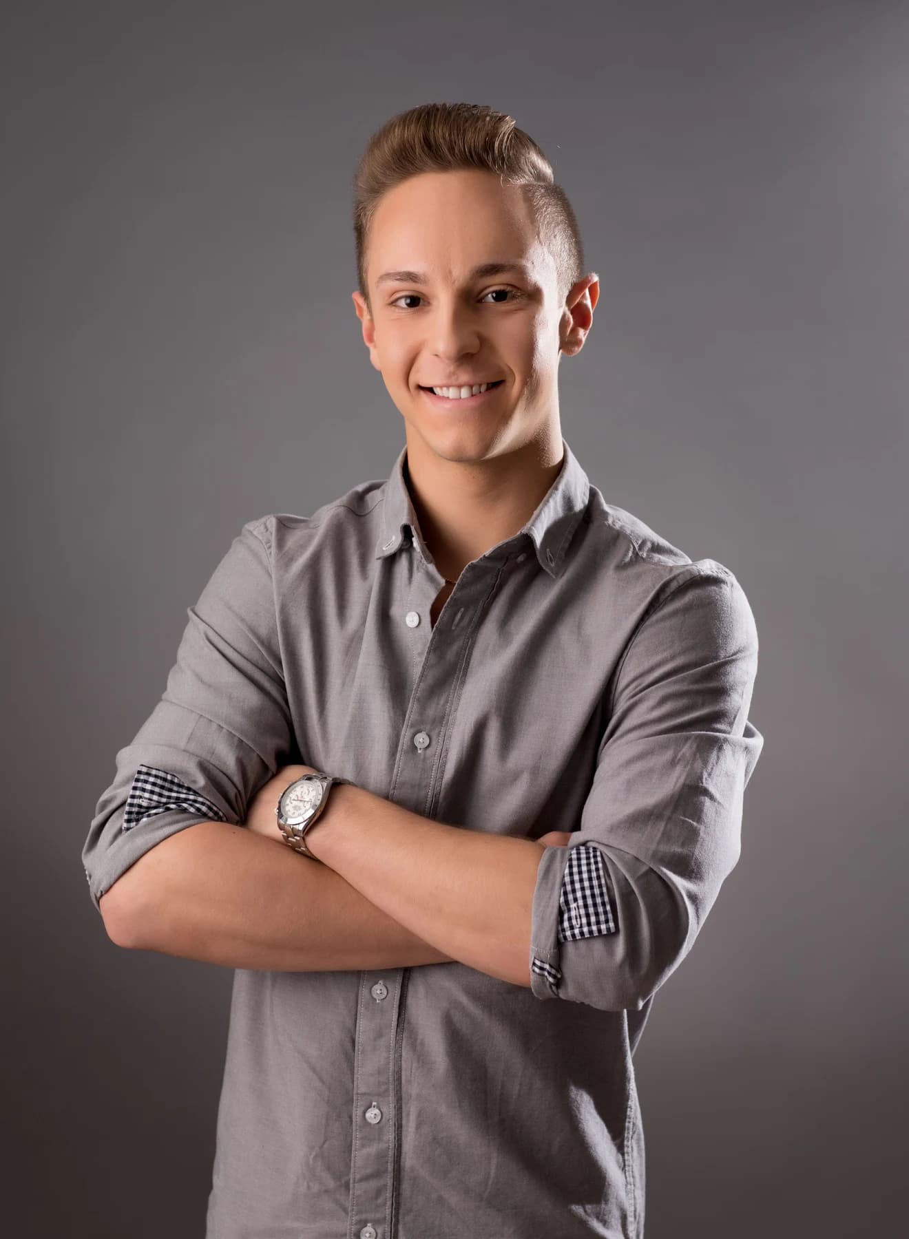 Jordan wearing a gray shirt with his arms folded in a studio portrait.