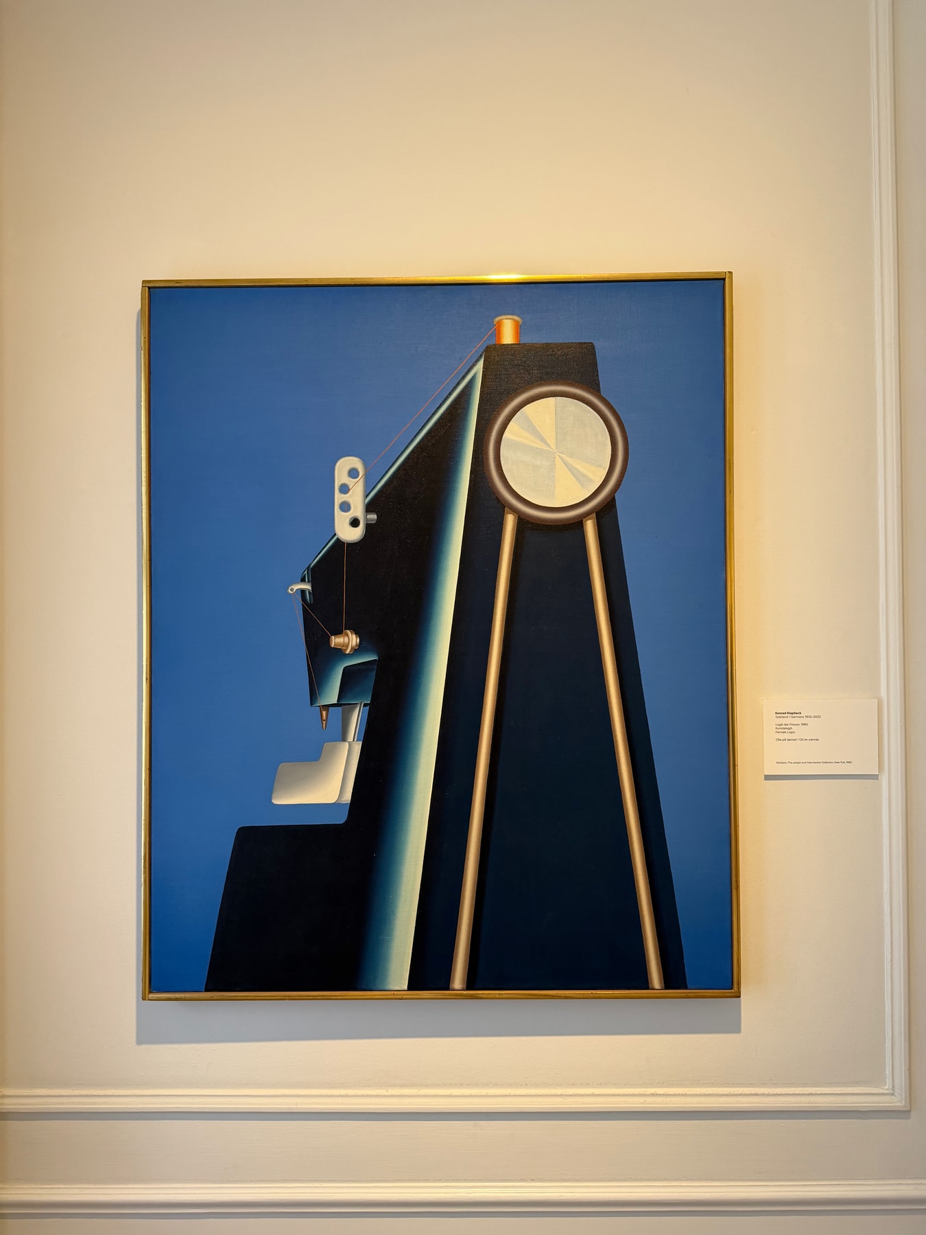 Female Logic by Konrad Klapheck, photographed in its gold frame against a museum wall.